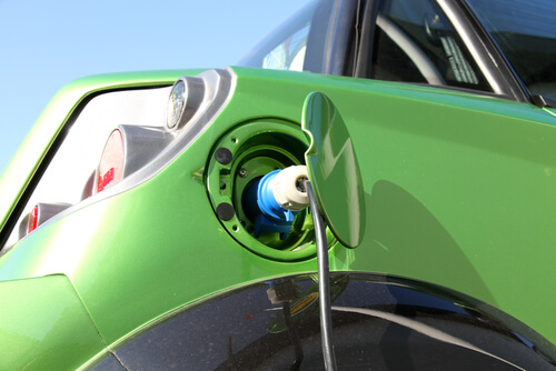 Green electric car getting charged