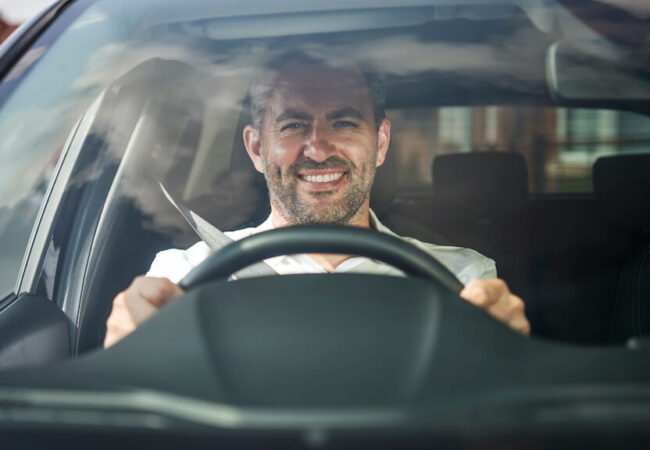 Driving instructor smiling at wheel